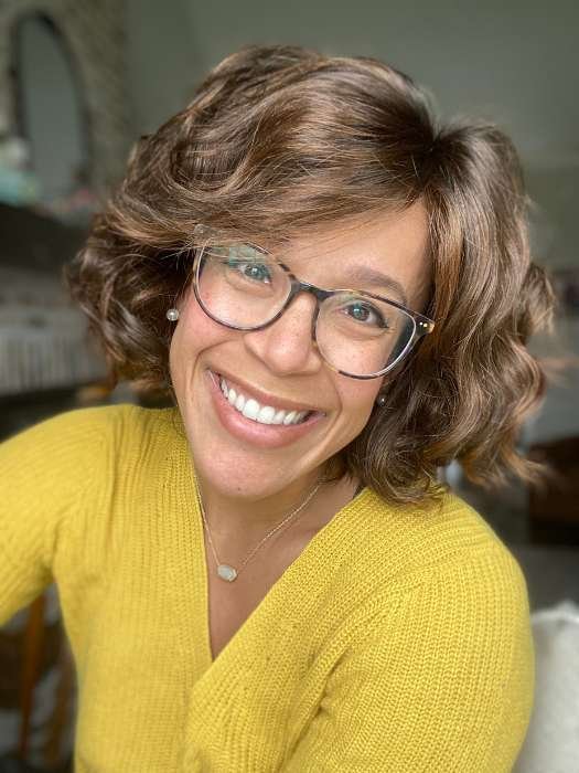 Ellen Wille Girl Mono wig displayed on a smiling woman with curly hair and glasses