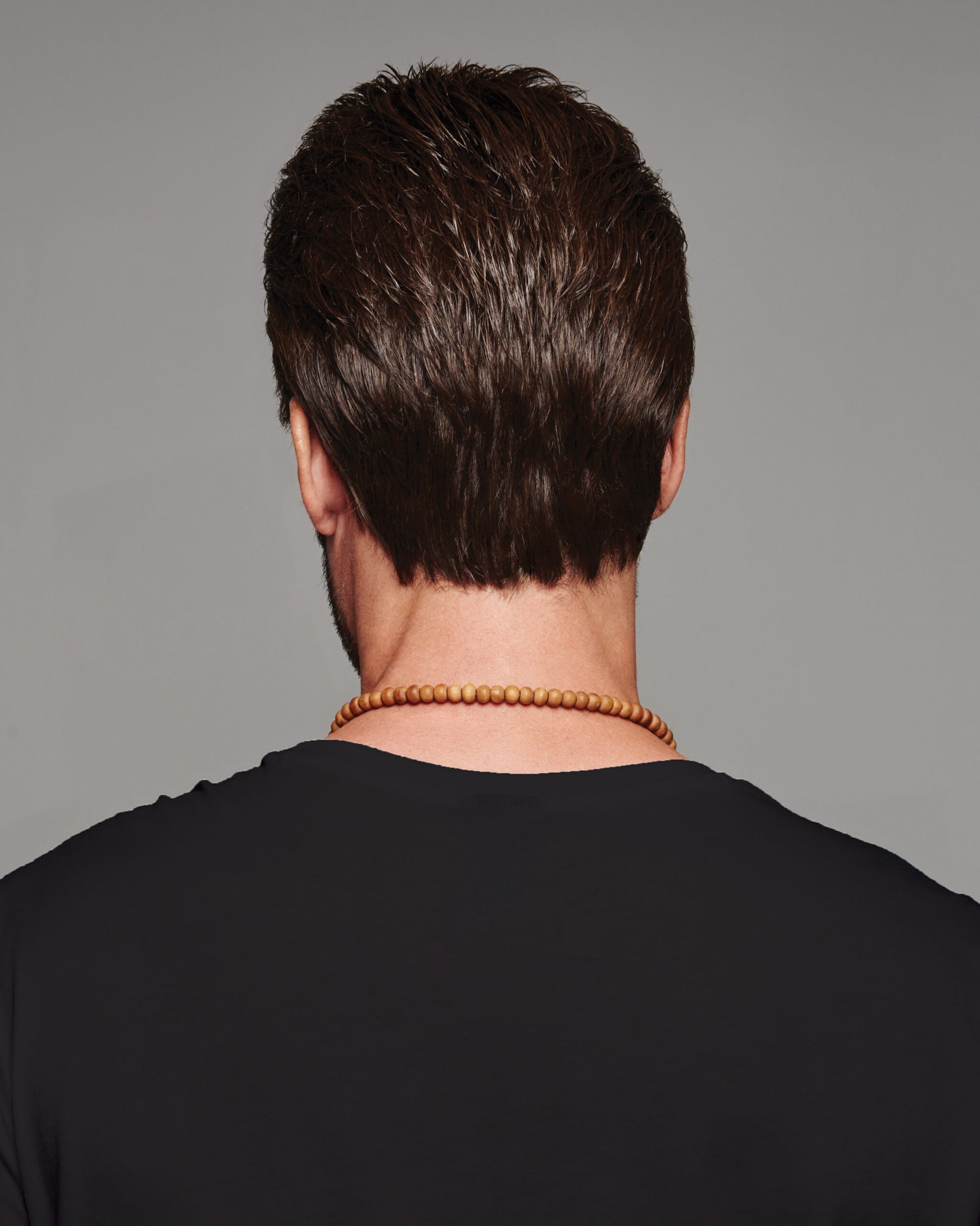 Back view of a HairUWear men's natural look wig in dark brown short tapered cut on model