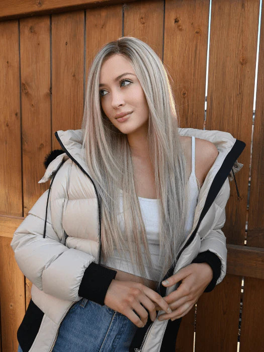 Long wavy synthetic wig in blonde tones styled casually with a puffer jacket