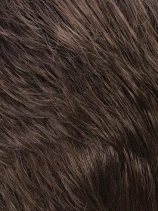 Close-up view of a monofilament hair topper for thinning hair featuring textured brown strands