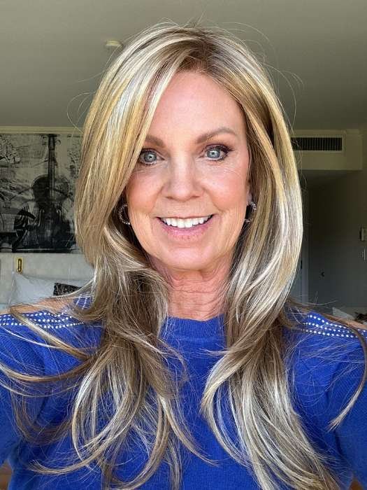 Woman wearing Zara wig by Rene of Paris long layered blonde with face framing highlights and natural hairline